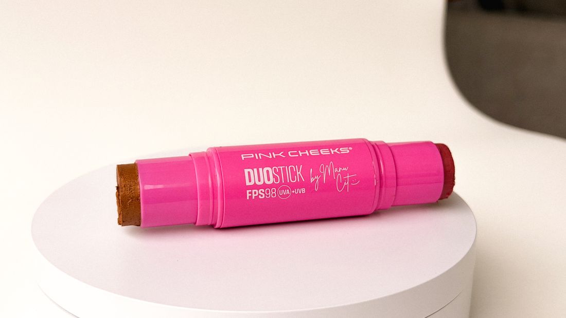 Bastão rosa sobre pedestal branco